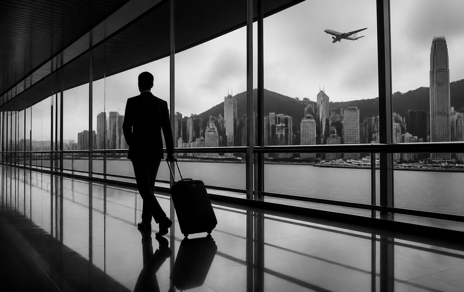 Business traveller at an airport terminal with city skyline